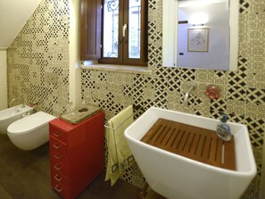 Un bagno con due servizi igienici, un lavandino e una finestra.