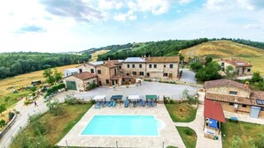 Un'ampia villa con piscina, diverse camere per gli ospiti e un cortile.