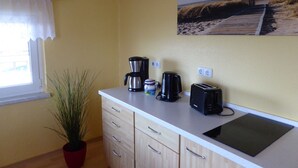 A small kitchenette with a coffee maker, toaster, and a potted plant. - Ferienhaus mit Balkon und Garten in Zweedorf (Bastorf)