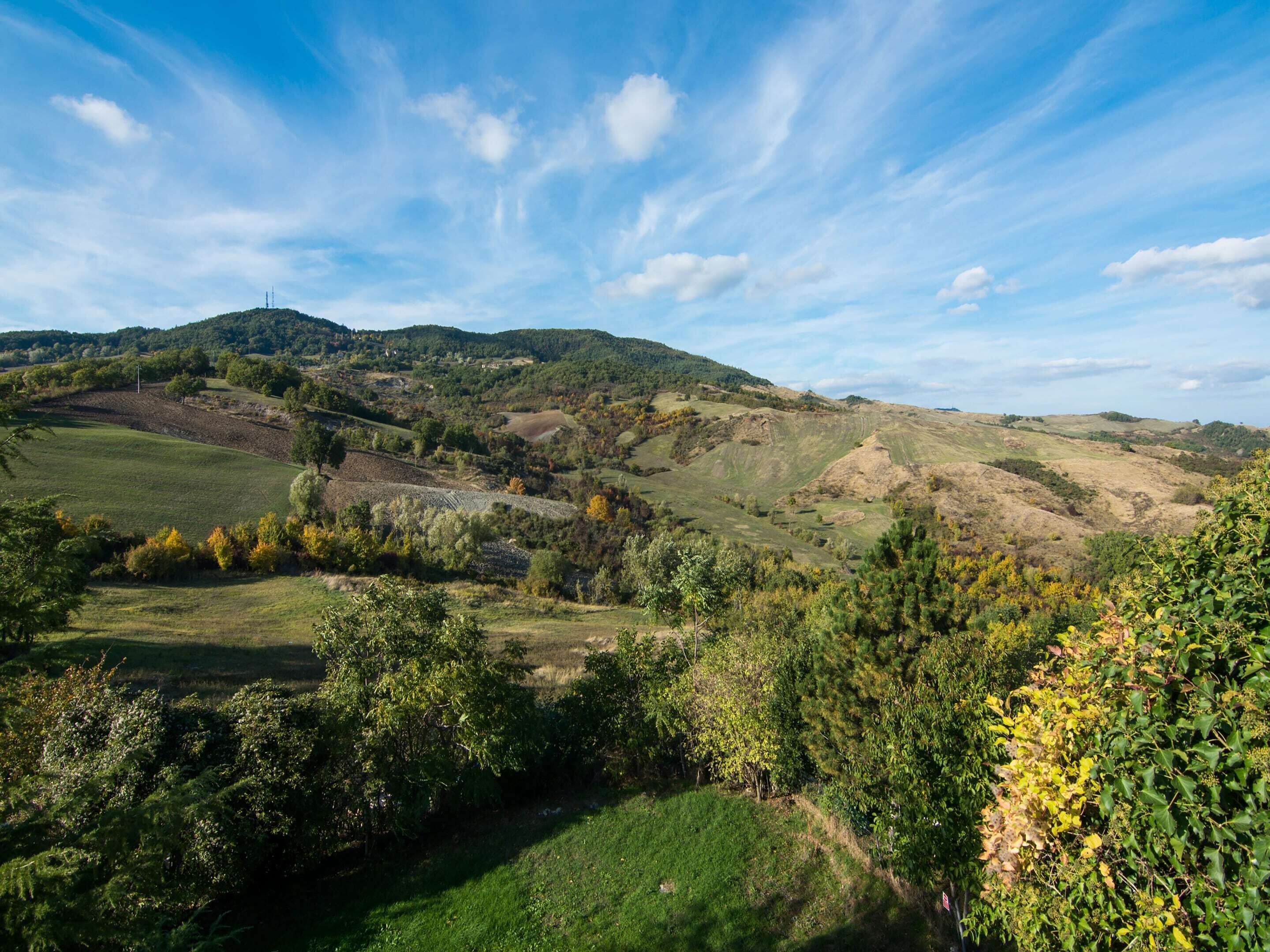 A panoramic view of a hilly landscape with a clear sky.