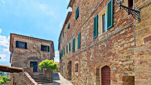 A narrow street with stone buildings, a staircase, and a small tree. - Cozy 2-bedroom Apartment (Castelnuovo di Val di Cecina)