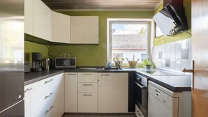 A compact kitchen with white cabinets, a microwave, a coffee maker, and a dishwasher. - Tranquil Apartment in Marktleuthen near River & Forest (Marktleuthen)