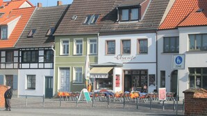 Una hilera de edificios europeos tradicionales con un café llamado 'Ciscae' en el centro.