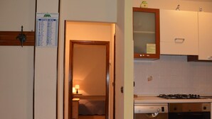 A kitchen with a Bosch dishwasher and stove, a wooden cabinet, and a door with a calendar. - Serene Chalet in Antey-Saint-André near Ski Area (Antey-Saint-Andre)