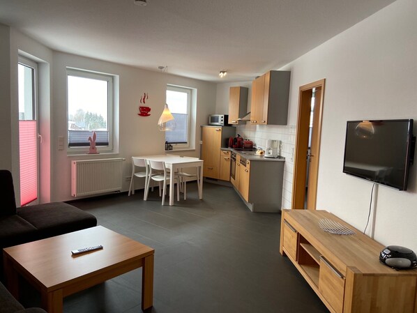 Un apartamento moderno con sala de estar, comedor y cocina.