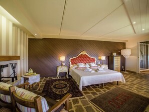 Ett hotellrum med en stor säng, två sängbord, en stol, en matta och en stor spegel.