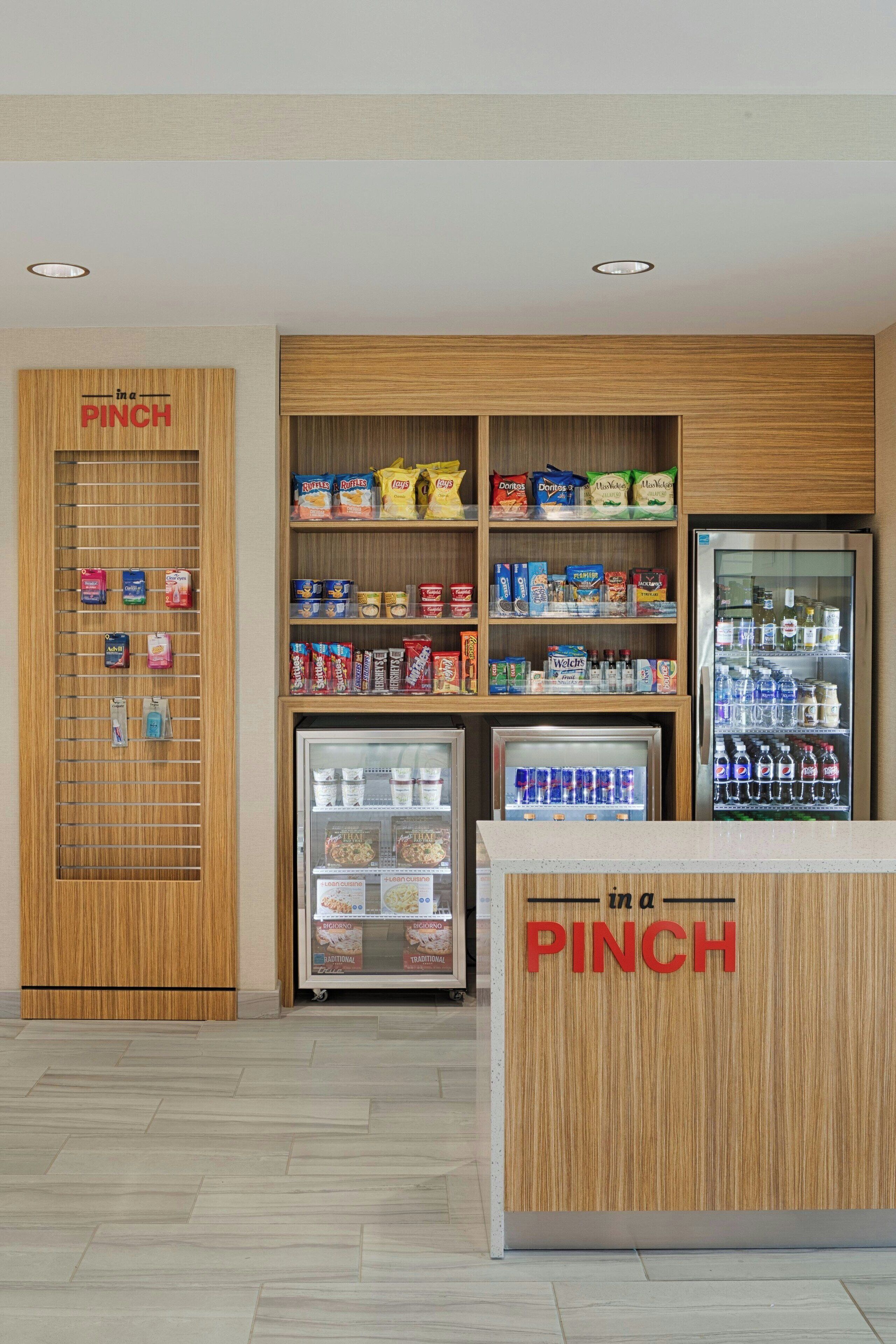 Zona de venta de aperitivos con mostrador de madera y vitrinas refrigeradas.