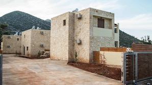 A modern building with stone walls and satellite dishes, set against a mountainous backdrop. - Beach View Villa in Bali near City Center with Private Pool (Mylopotamos)