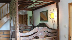 A four-poster bed with intricate carvings, a wooden staircase, and a mirror with a sun design. - Landhaus in Gressow mit Terrasse (Gaegelow)