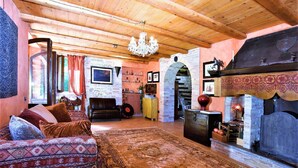 A cozy room with a patterned sofa, a fireplace, and a wooden ceiling. - Elegant Villa in Montecosaro Italy with Hot Tub (Montecosaro)
