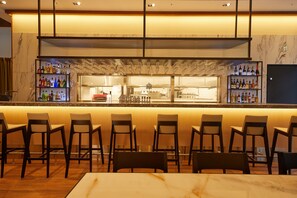 A bar area with seating and a counter displaying various bottles and glasses. - MGH Mitsui Garden Hotel Taipei Zhongxiao (Taipei)