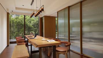 Uma sala de jantar moderna com uma mesa de madeira comprida, várias cadeiras e um banco.