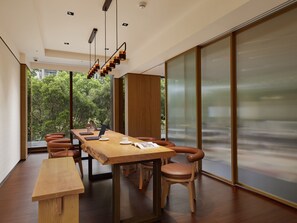 A modern dining area with a long wooden table, multiple chairs, and a bench. - MGH Mitsui Garden Hotel Taipei Zhongxiao (Taipei)