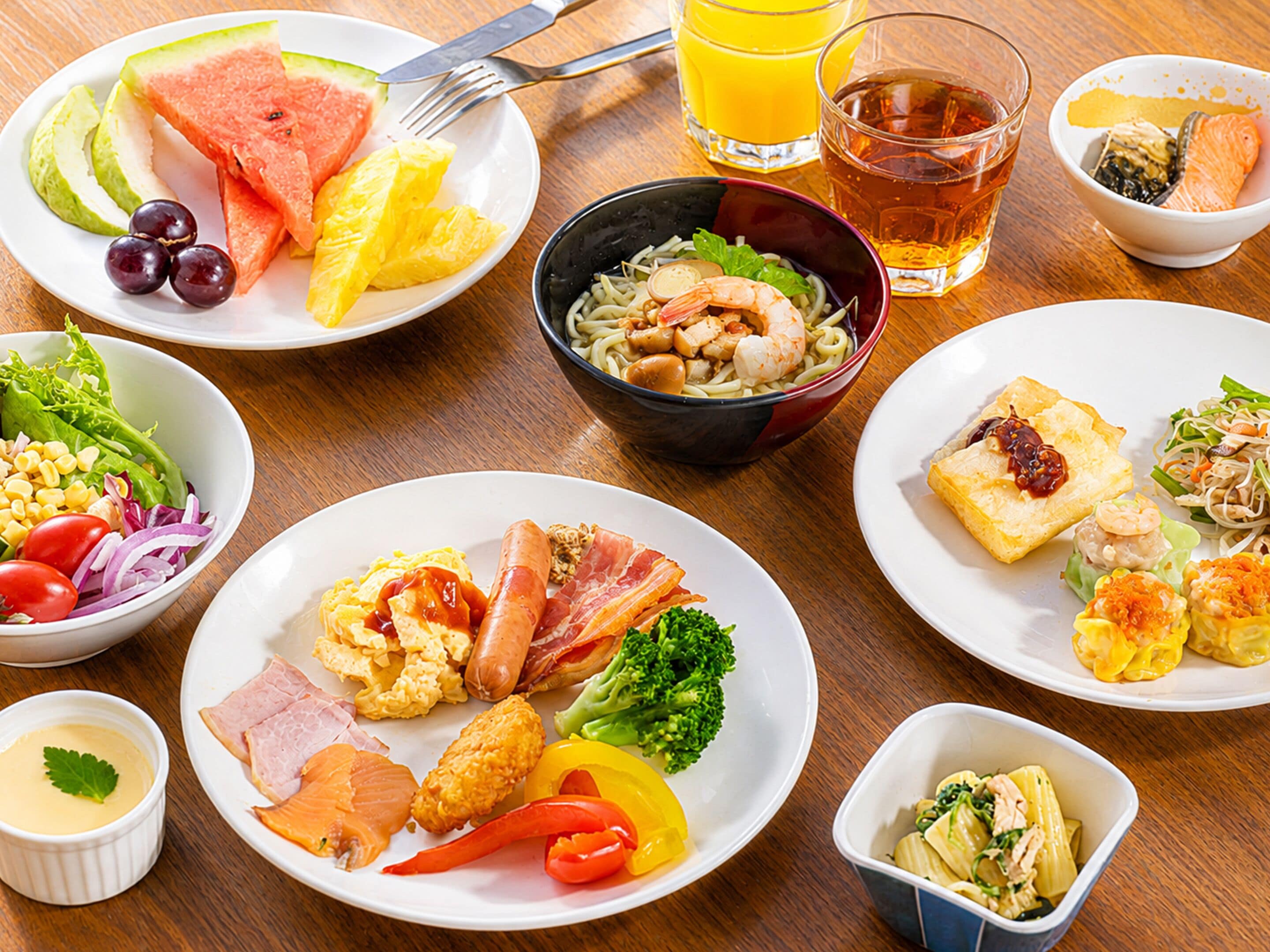 A variety of dishes including seafood, vegetables, and fruits on a wooden table.