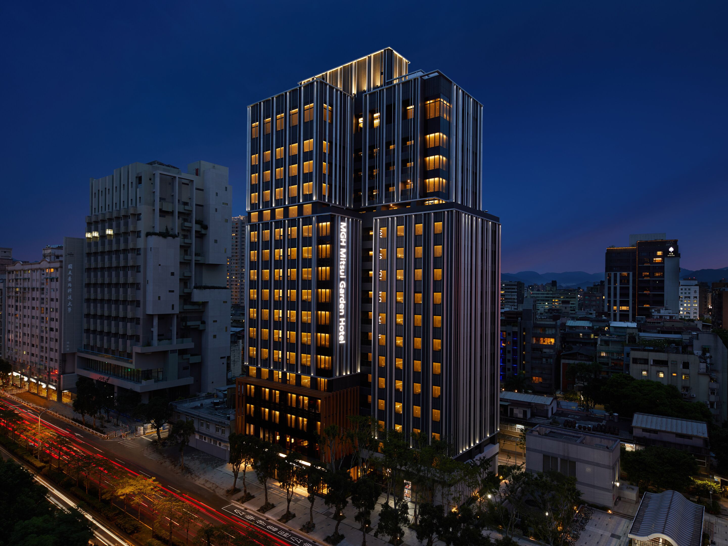 Un hôtel à plusieurs étages, doté d’un design moderne, et dont la façade est caractérisée par une large bande verticale de fenêtres.