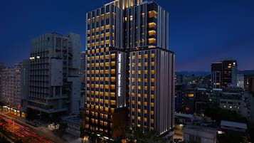 A multi-story hotel with a modern design, featuring a prominent vertical strip of windows on the facade.