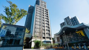 Un edificio moderno con fachada de vidrio y un cartel que indica que es el tercer piso.