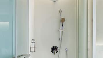 A modern shower with a handheld showerhead, a wall-mounted faucet, and a control panel.