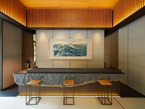 A modern bar area with a wooden slatted ceiling, a framed abstract painting, and three stools. - MGH Mitsui Garden Hotel Taipei Zhongxiao (Taipei)