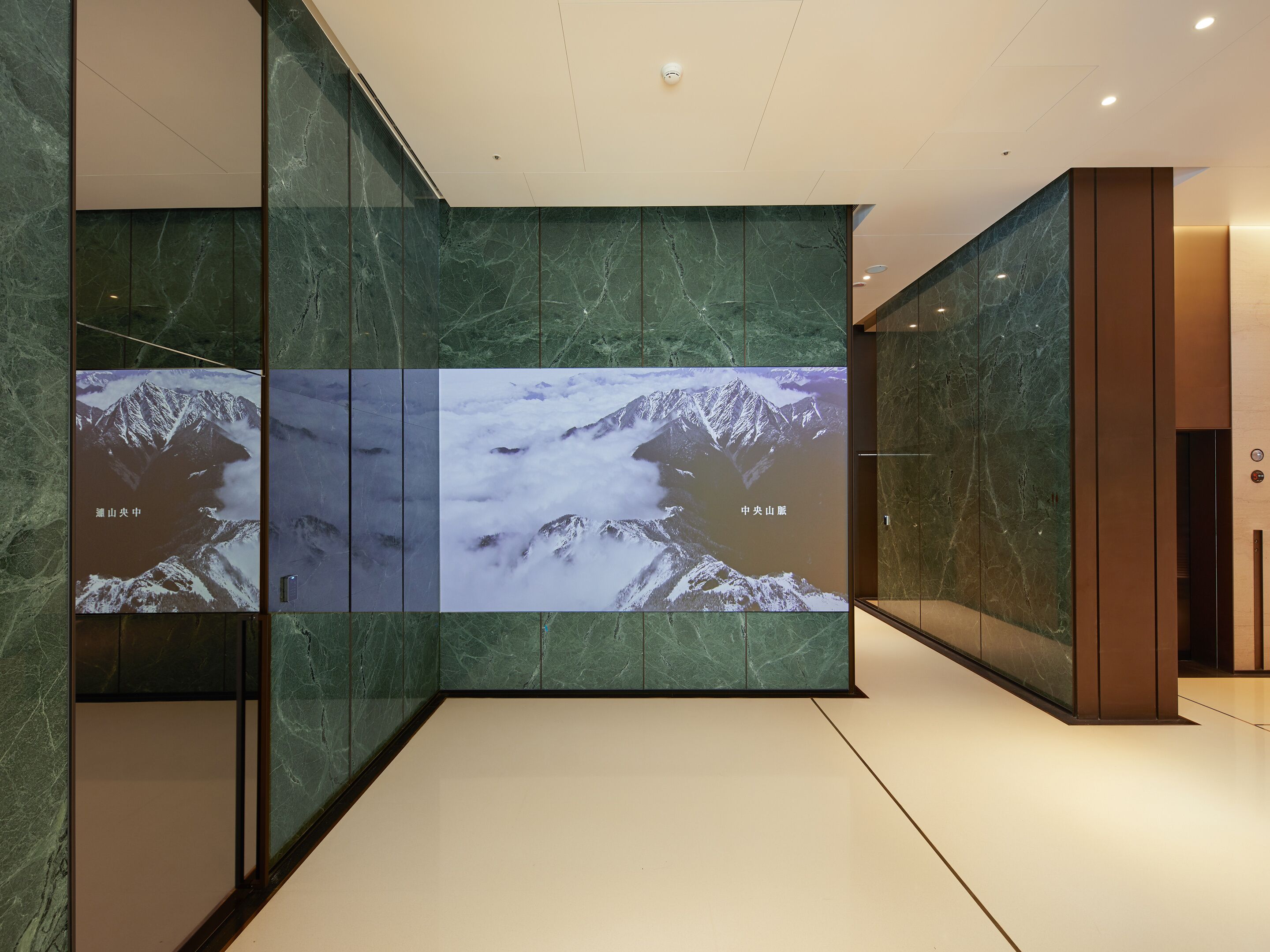 A modern interior with a large digital display featuring mountain landscapes.