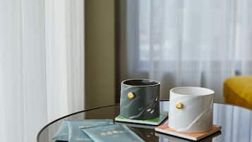 Una mesa de vidrio con dos tazas, una bandeja y algunos sobres.