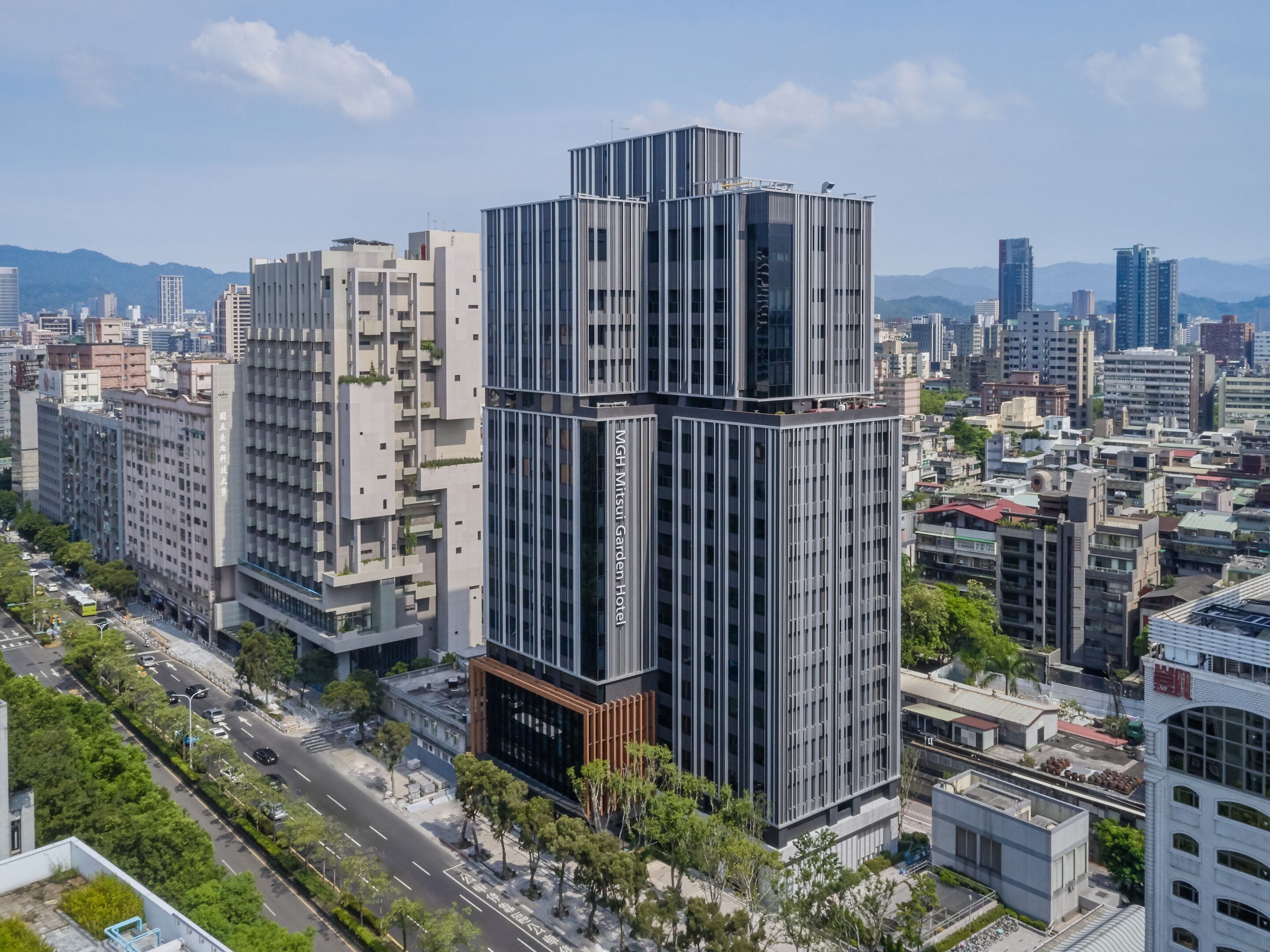 A modern hotel with a unique stacked design, surrounded by a cityscape.