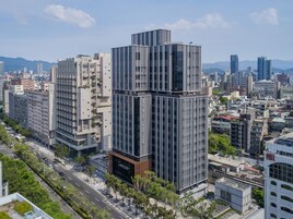 Un hotel moderno con un diseño original en estructura escalonada, rodeado por un paisaje urbano.
