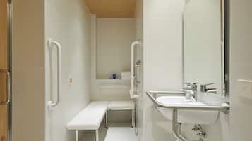 A modern bathroom with a bench, a sink with a mirror, and a shower area.