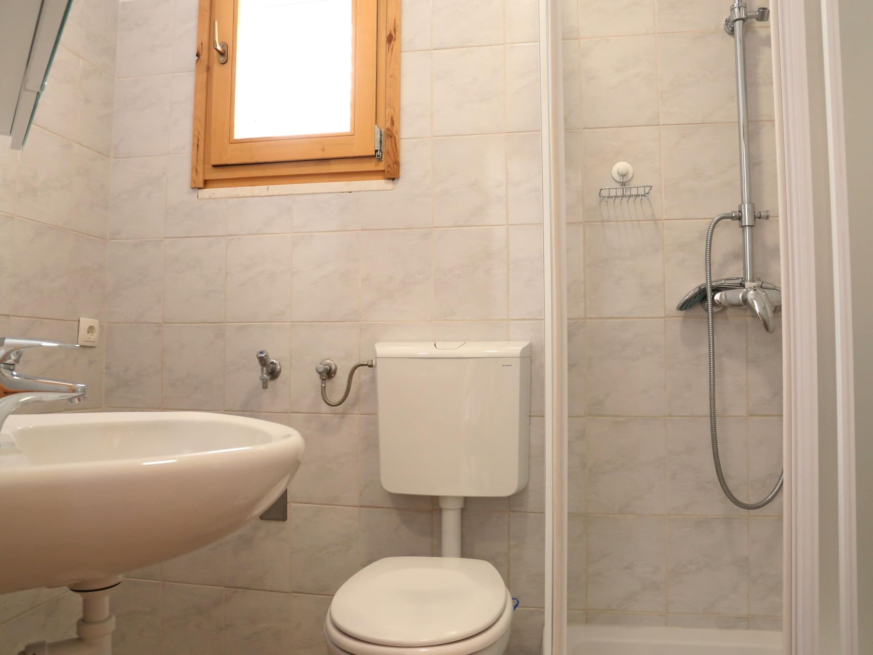 A bathroom with a sink, toilet, and shower.