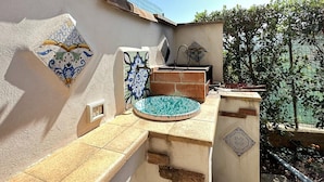 A tiled outdoor area with a small pool, a wall with decorative tiles, and a hanging lantern. - Charming Holiday Home Near Sea (Castellammare del Golfo)