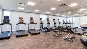 A gym with treadmills, elliptical machines, and a rowing machine.