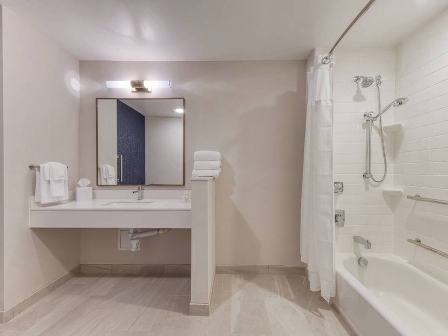 Ein modernes Badezimmer mit Waschbecken, Spiegel und Badewanne.