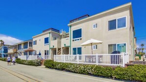 A beachfront hotel with multiple-story buildings, balconies, and a white fence. - Belmont Park And  Sea World Boardwalk Bungalow  (San Diego)