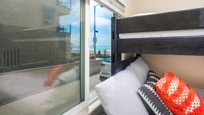 A room with a bunk bed, a large window, and a view of the beach. - Belmont Park And  Sea World Boardwalk Bungalow  (San Diego)