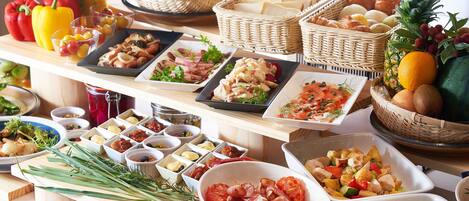 A buffet table with various food items and fresh produce.