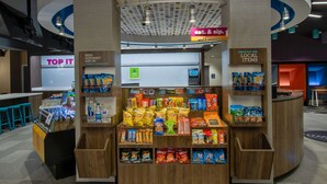 A snack kiosk with various packaged snacks and a water dispenser. - Tru by Hilton Columbus Airport (Columbus)