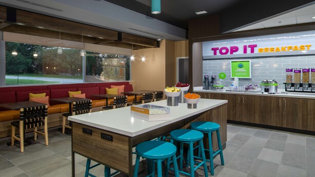 A breakfast area with a counter, stools, and seating. - Tru by Hilton Columbus Airport (Columbus)