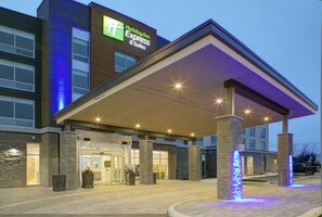 A Holiday Inn Express & Suites building with a covered entrance, stone pillars, and a well-lit facade. - Holiday Inn Express & Suites Collingwood by IHG (Collingwood)
