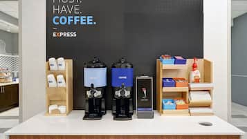 Una estación de café con dos dispensadores de café, un dispensador de agua y un letrero que dice "MUST. HAVE. COFFEE".