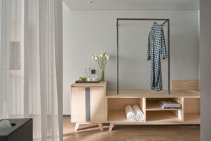 A modern bathroom with a wooden vanity, a towel rack, and a mirror.