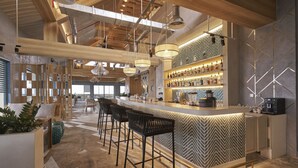A modern bar area with a long counter, multiple stools, and a variety of bottles. - The Secret Con Dao (Ho Chi Minh City)