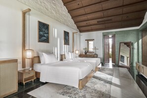 A spacious bedroom with a large bed, bedside tables, and a view of a balcony. - The Secret Con Dao (Ho Chi Minh City)