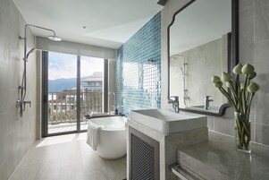 A modern bathroom with a freestanding bathtub, a large mirror, and a glass shower enclosure.