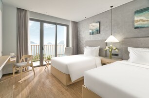 Una habitación de hotel moderna con dos camas, un escritorio y una silla.