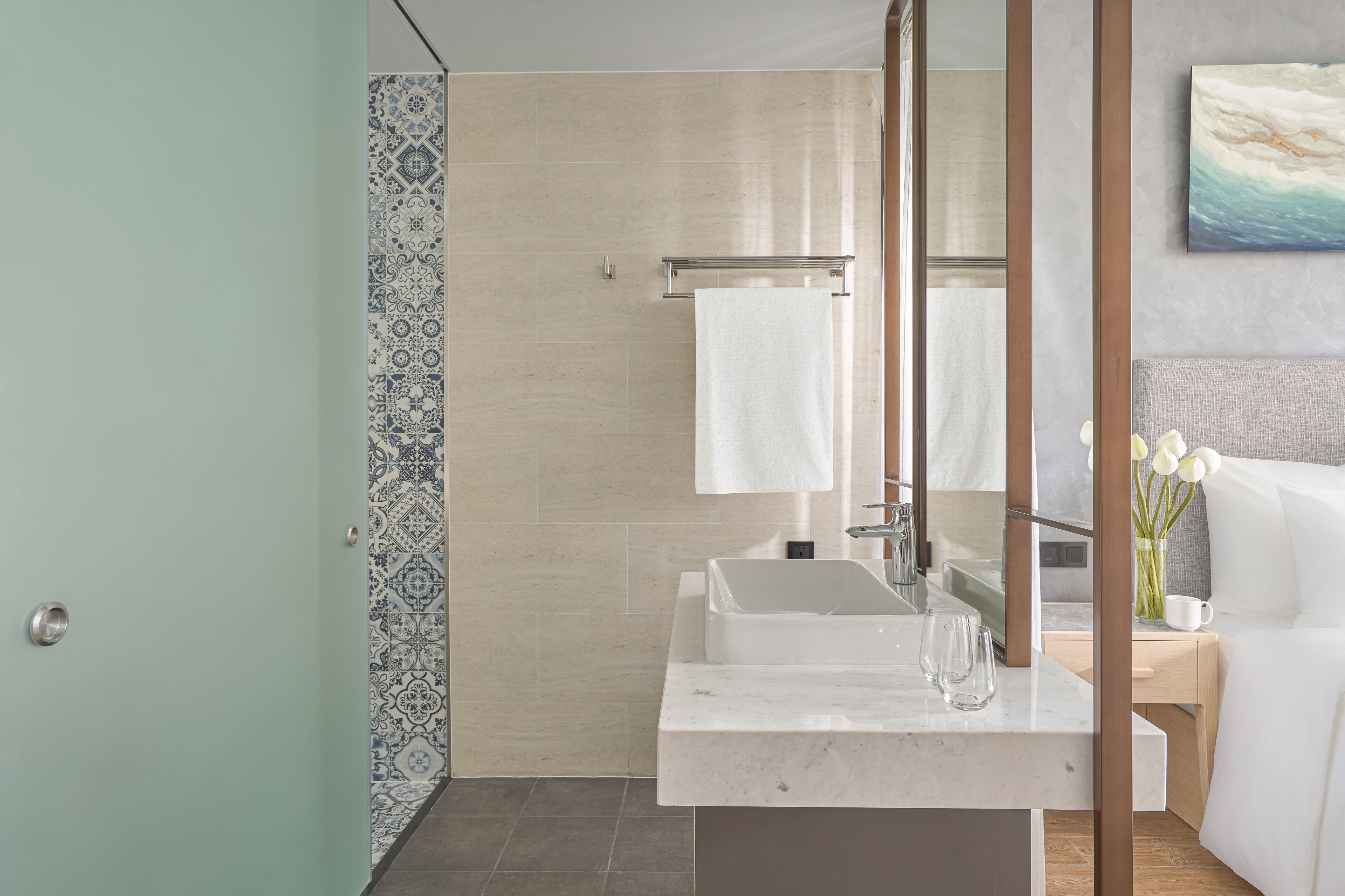 Un baño moderno con un espejo grande, un lavamanos y una zona de ducha.