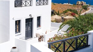 A white building with balconies, a door, and a window. - Soulis Hotel (Santorini)