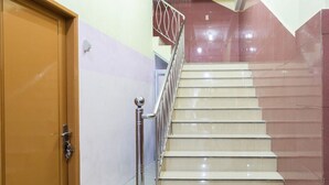 Un escalier avec une porte en bois et une rampe en métal.