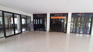 A modern building with glass doors and a sign for 'Umamie Coffee'. - RedDoorz Plus @ Bitung City Center (Bitung)