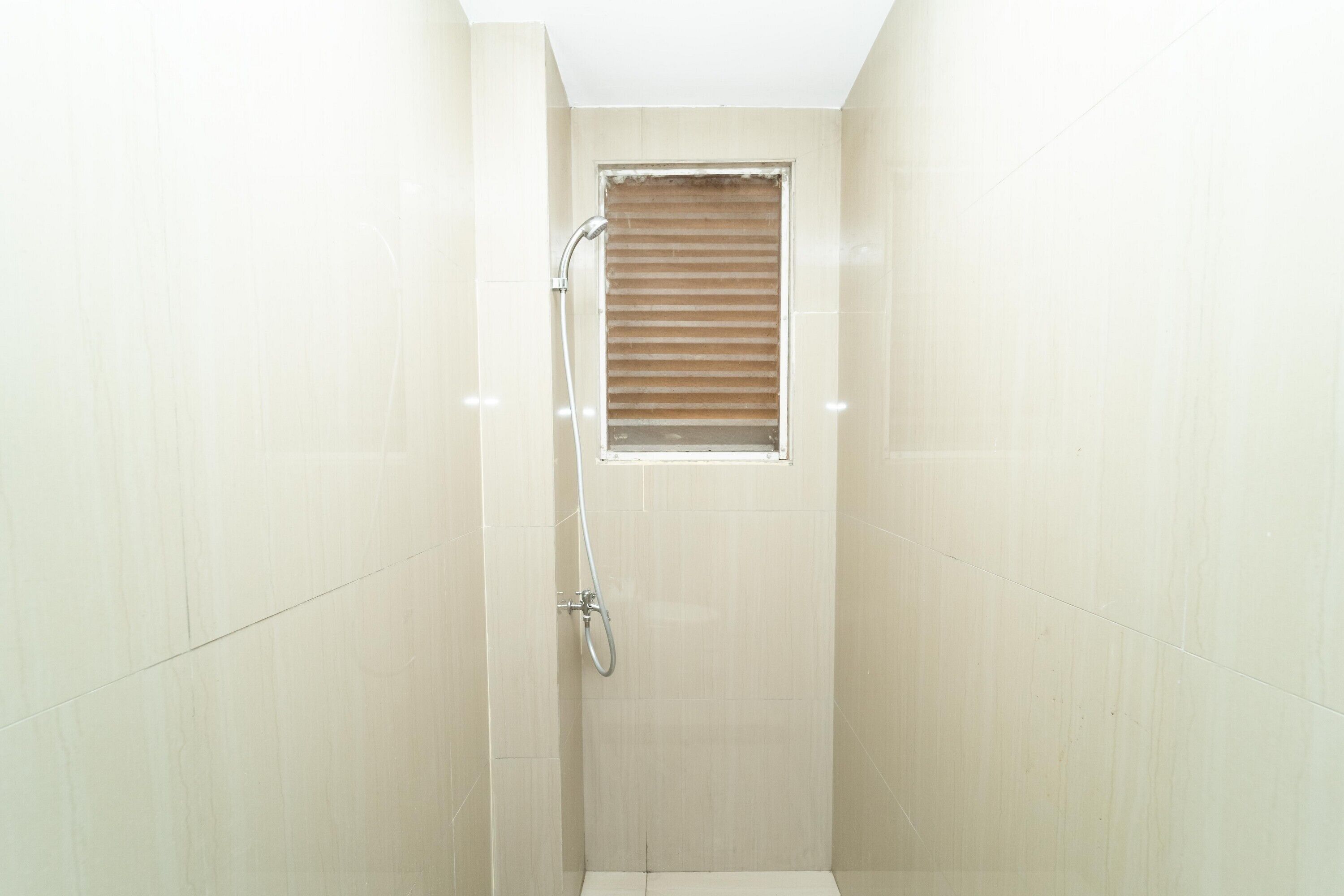 A small, enclosed shower area with a showerhead and a window.