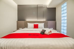 A hotel room with a large bed, a red bedspread, and a window with a view. - RedDoorz Plus near Akademi Kepolisian Semarang 3 (Semarang)